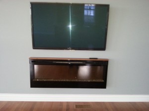 50" Panasonic LED panel wall mounted above an in wall electric fireplace